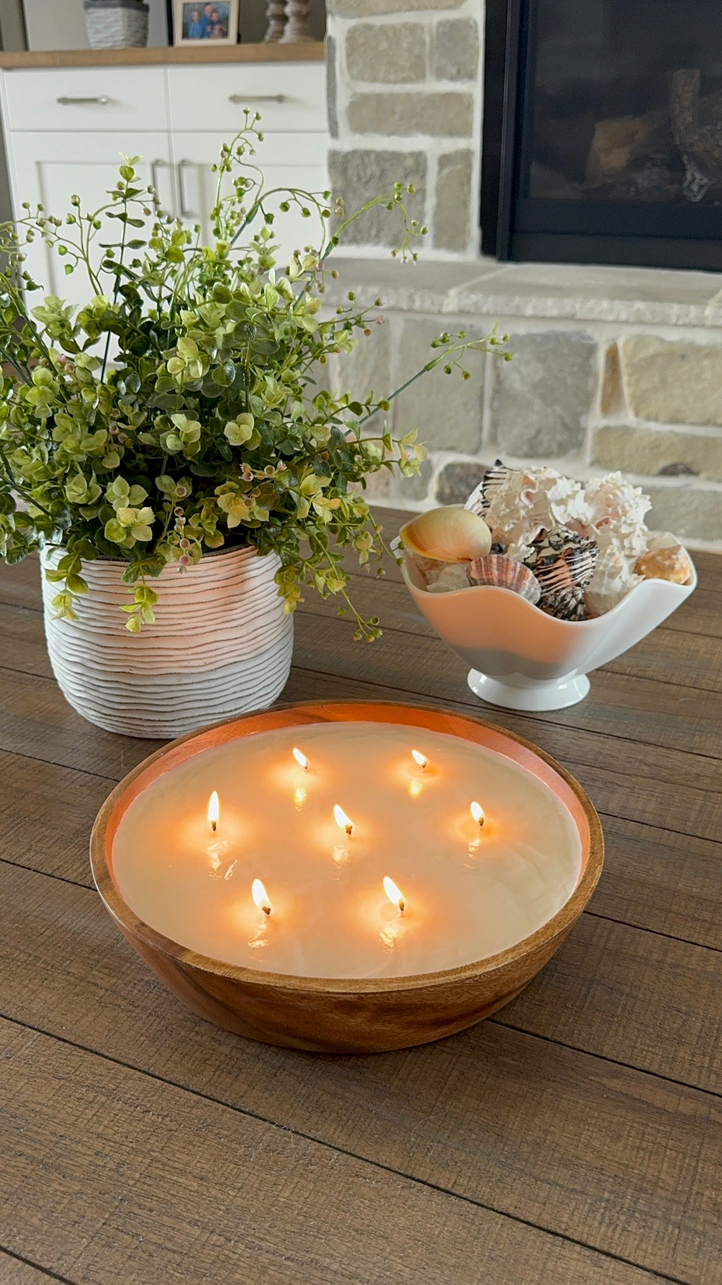 Top view of lit scented candle in front of fireplace. luxury candle on coffee table