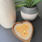 Top View of Lit wood bowl luxury scented candle on side table.