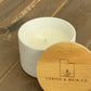 side view of 5 ounce ceramic jar scented candle with lid on table. 