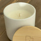 side view of unlit 10 ounce scented candle with lid.  Luxury ceramic jar candle on table. 